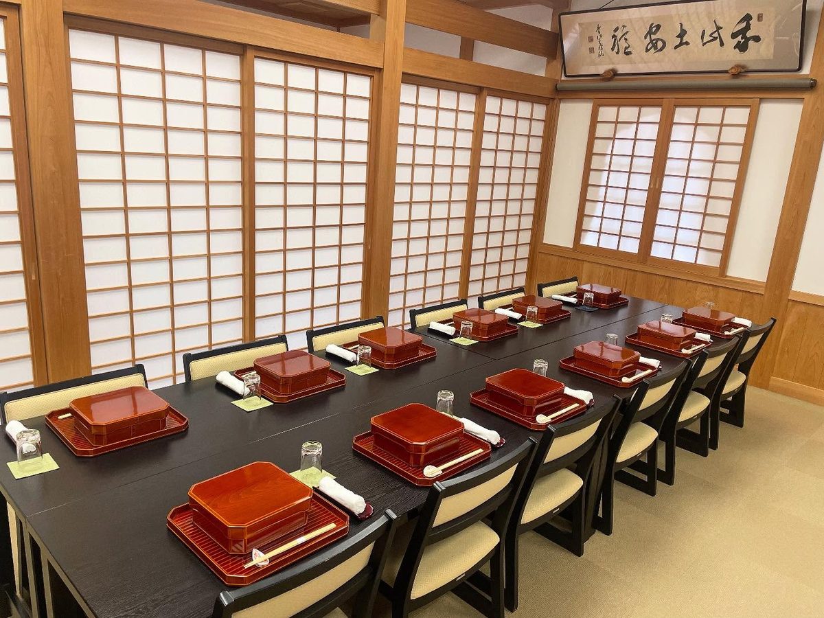 広間に整えられた朱塗りの弁当箱が人数分並ぶ